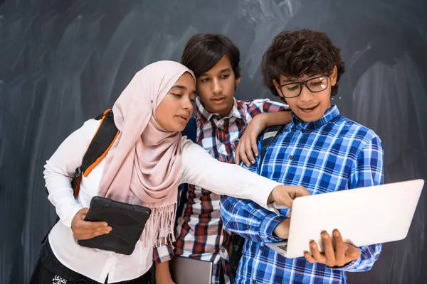 Gruppo di adolescenti arabi, gruppo di studenti che lavorano insieme su computer portatile e tablet concetto di istruzione in aula online — Foto Stock