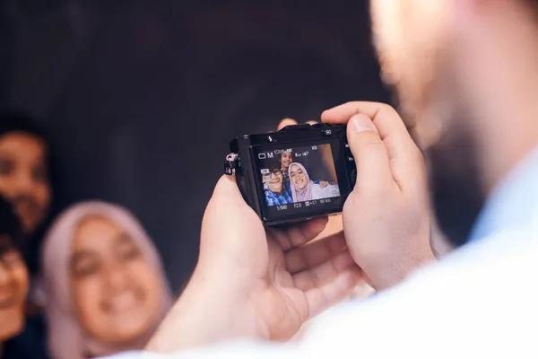Un padre con una cámara fotográfica fotografía a sus hijos mientras posan con una sonrisa en la cara —  Fotos de Stock