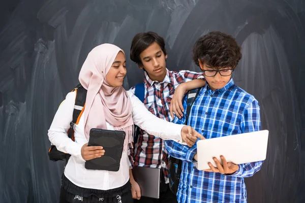Équipe d'adolescents arabes, groupe d'étudiants travaillant ensemble sur ordinateur portable et tablette concept d'éducation en classe en ligne — Photo