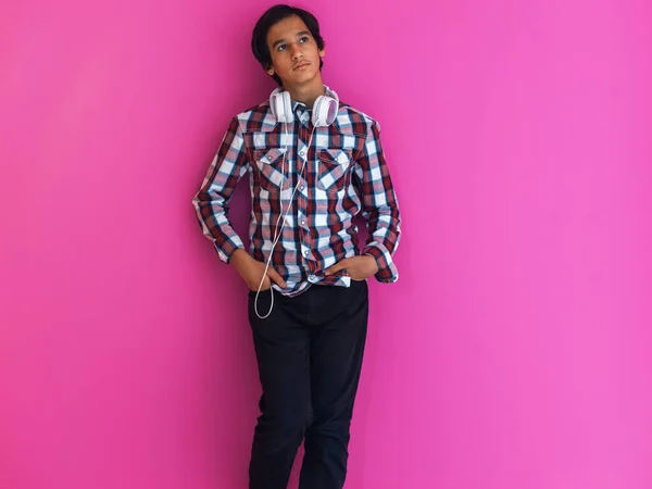 Arabische Teenager tragen Kopfhörer und hören Musik rosa Hintergrund — Stockfoto