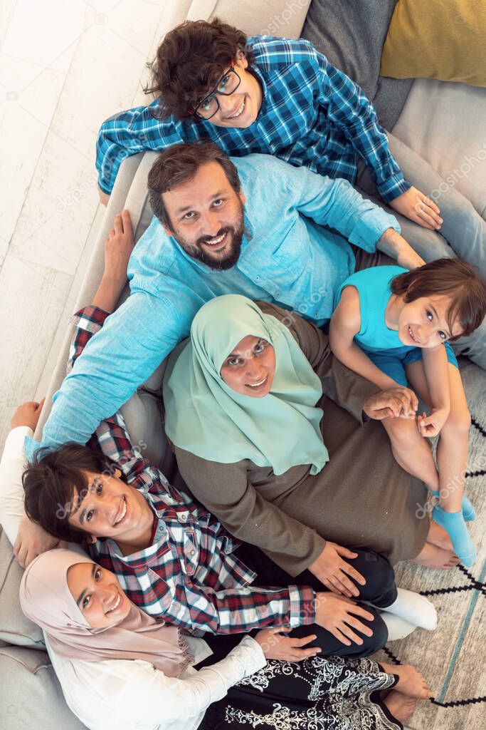 Top view photo of an Arab family sitting in the living room of a large modern house.Selective focus 