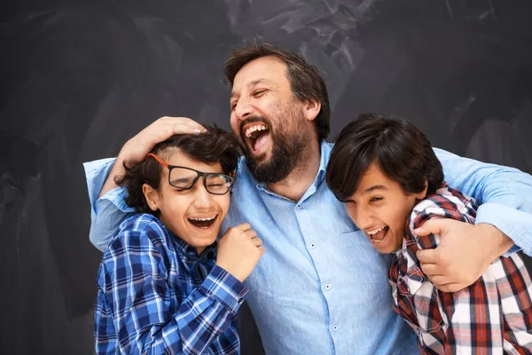 Šťastný otec objímání synů nezapomenutelné okamžiky rodinné radosti ve smíšené rasy střední východ arabské rodiny — Stock fotografie