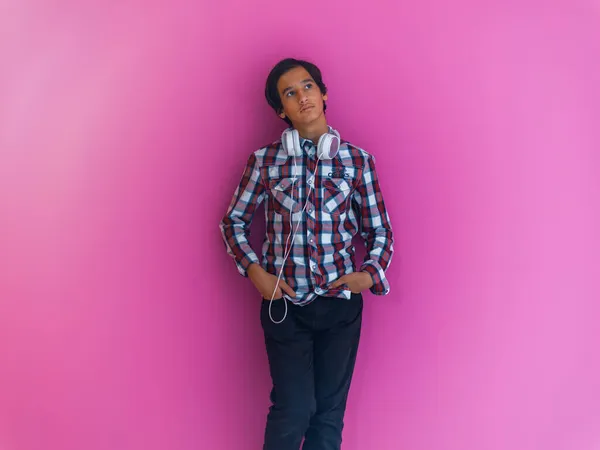 Árabe adolescente niño usando auriculares y escuchar música rosa fondo — Foto de Stock