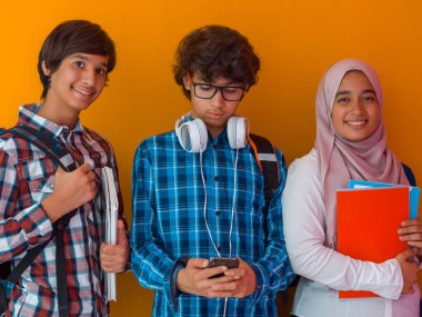 Bir grup Arap ergen, geleceğe doğru yürüyen bir öğrenci takımı ve okula sarı arka plan kavramı. Gençler için başarılı eğitim kavramı. Seçici odak