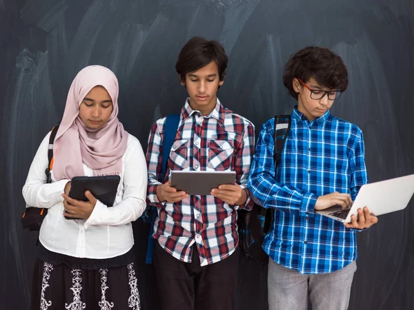 Adolescentes árabes modernos usan teléfonos inteligentes, tabletas y latpop para estudiar durante las clases en línea debido a la pandemia del virus corona — Foto de Stock