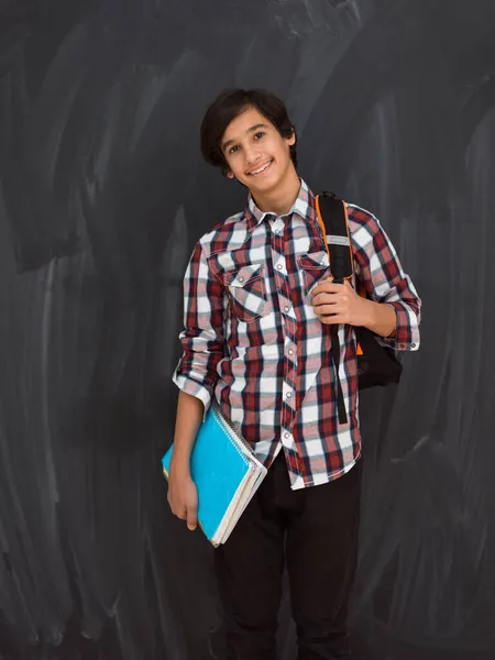 Arabo adolescente con zaino indossare casual scuola look contro nero lavagna sfondo — Foto Stock