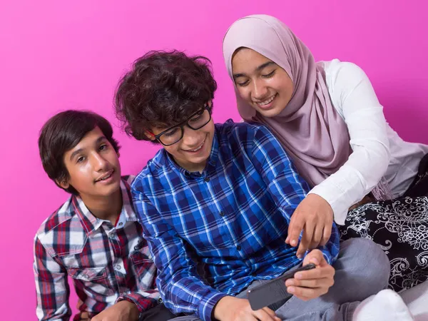 Grupo de adolescentes árabes usando teléfonos inteligentes para redes sociales y compartiendo información para la educación en línea —  Fotos de Stock