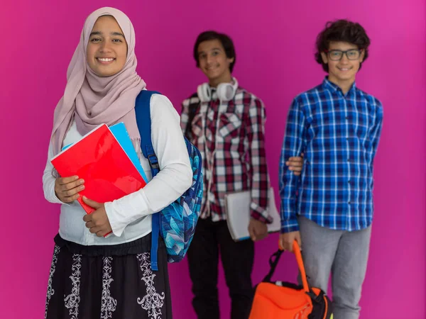Arab tinédzserek egy csoportja, egy diákcsapat, akik előre sétálnak a jövőbe és vissza az iskolába a rózsaszín háttér fogalmát. A fiatalok sikeres oktatásának koncepciója. Szelektív fókusz — Stock Fotó