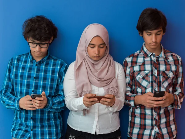 Grupo de adolescentes árabes usando telefones inteligentes para redes sociais e compartilhamento de informações para a educação on-line — Fotografia de Stock