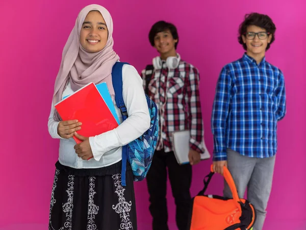 Un gruppo di adolescenti arabi, una squadra studentesca che cammina verso il futuro e torna a scuola il concetto di sfondo rosa. Il concetto di educazione di successo per i giovani. Focus selettivo — Foto Stock