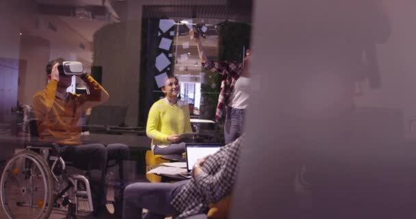 वर्चुअल रियलिटी चश्मा और ड्रोन सिमुलेशन का उपयोग करके टीम की बैठक में आधुनिक ओपन स्पेस सहकर्मी कार्यालय में काम पर एक व्हीलचेयर में विकलांग व्यापारी। स्टार्टअप व्यवसाय में प्रभावी टीमवर्क . — स्टॉक वीडियो