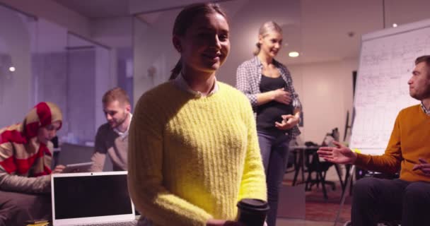 Retrato de una joven empresaria como líder de equipo mirando a la cámara y sonriendo. Compañeros multiétnicos en segundo plano Equipo diverso en la moderna oficina de inicio de espacios abiertos. Foto de alta calidad — Vídeo de stock