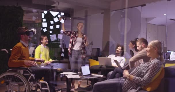 Behinderte Geschäftsleute im Rollstuhl bei der Arbeit in einem modernen Coworking-Büro im offenen Raum bei Teambesprechungen mit Virtual-Reality-Brillen und Drohnen-Simulation. Effektive Teamarbeit in einem Start-up-Unternehmen. — Stockvideo