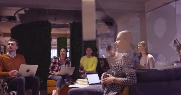 現代的なオープンスペースの同僚のオフィスでイスラム教徒の女性がチームにプレゼンテーションを行います。創造的なスタートアップオフィスで中東アラブのビジネス女性。チームミーティングの車椅子の障害者事業者 — ストック動画
