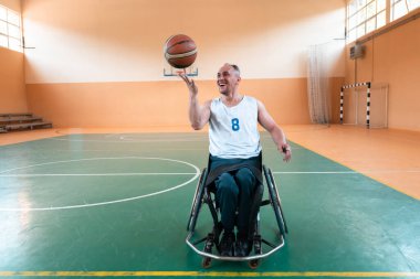 Tekerlekli sandalye ve engelli savaş gazilerinin sahada basketbol oynarken çekilmiş yakın bir fotoğrafı. Seçici odak 