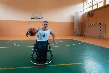 Modern bir spor salonunda basketbol oynayan bir savaş gazisinin fotoğrafı. Engelliler için spor kavramı. Yüksek kalite fotoğraf