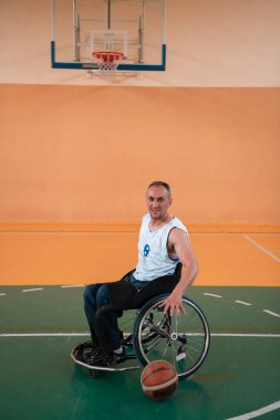 Modern bir spor salonunda basketbol oynayan bir savaş gazisinin fotoğrafı. Engelliler için spor kavramı. Yüksek kalite fotoğraf
