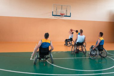 Engelli savaş gazileri ve tekerlekli sandalyeli yaş basketbol takımları spor salonunda antrenman yapıyorlar. Özürlülerin rehabilitasyonu ve kapsama konsepti