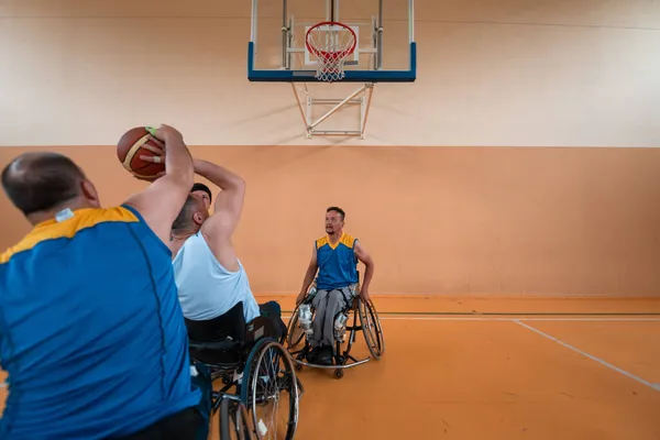 Gehandicapten Oorlog veteranen gemengd ras en leeftijd basketbal teams in rolstoelen spelen van een trainingswedstrijd in een sporthal. Rehabiliteits- en integratieconcept voor gehandicapten — Stockfoto