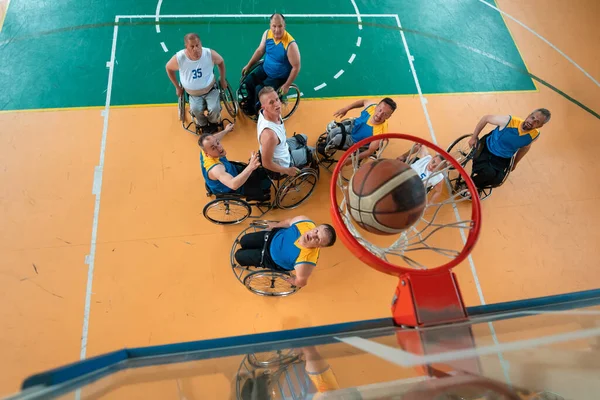 残疾战争或退伍老兵混合种族篮球队和年龄篮球队 他们坐在轮椅上 在体育馆进行训练比赛 残疾人康复和融入社会的概念 顶部视图 — 图库照片