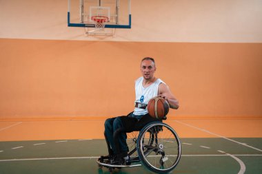 Modern bir spor salonunda basketbol oynayan bir savaş gazisinin fotoğrafı. Engelliler için spor kavramı. Yüksek kalite fotoğraf