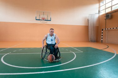 Modern bir spor salonunda basketbol oynayan bir savaş gazisinin fotoğrafı. Engelliler için spor kavramı. Yüksek kalite fotoğraf