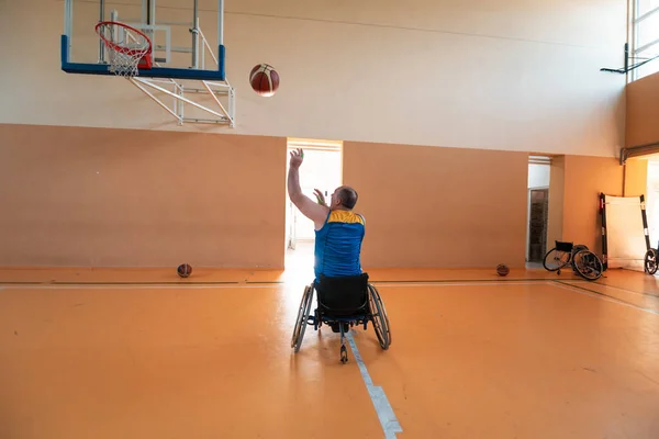 Gehandicapten Oorlog veteranen gemengd ras en leeftijd basketbal teams in rolstoelen spelen van een trainingswedstrijd in een sporthal. Rehabiliteits- en integratieconcept voor gehandicapten — Stockfoto