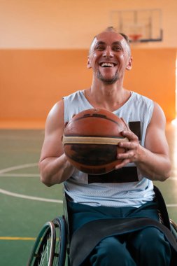 Tekerlekli sandalye ve engelli savaş gazilerinin sahada basketbol oynarken çekilmiş yakın bir fotoğrafı. Seçici odak 