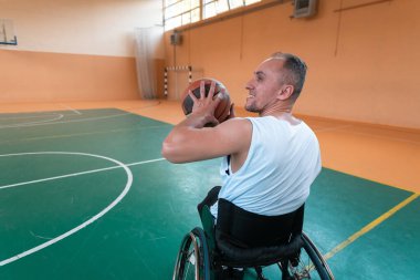 Modern bir spor salonunda basketbol oynayan bir savaş gazisinin fotoğrafı. Engelliler için spor kavramı. Yüksek kalite fotoğraf