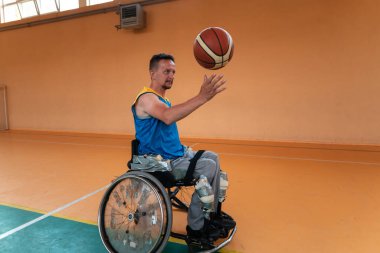 Engelli savaş gazileri ve tekerlekli sandalyeli yaş basketbol takımları spor salonunda antrenman yapıyorlar. Özürlülerin rehabilitasyonu ve kapsama konsepti