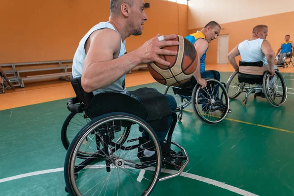 Gehandicapten Oorlog veteranen gemengd ras en leeftijd basketbal teams in rolstoelen spelen van een trainingswedstrijd in een sporthal. Rehabiliteits- en integratieconcept voor gehandicapten — Stockfoto