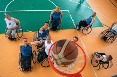 Engelli Savaşı ya da çalışma gazileri karışık ırk ve yaş basketbolu takımları spor salonunda antrenman maçı yapıyorlar. Özürlülerin rehabilitasyonu ve kapsama konsepti. Üst görünüm.