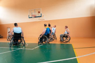 Engelli Savaşı ya da çalışma gazileri karışık ırk ve yaş basketbolu takımları spor salonunda antrenman maçı yapıyorlar. Özürlü insanlar rehabilitasyonu ve kapsama konsepti. Merhaba kaliteli fotoğraf.