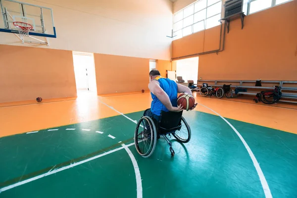 Deficientes veteranos de guerra mista raça e idade equipes de basquete em cadeiras de rodas jogando uma partida de treinamento em um ginásio de esportes salão. Conceito de reabilitação e inclusão de deficientes — Fotografia de Stock