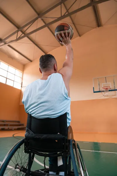Uma foto de um veterano de guerra a jogar basquetebol numa arena desportiva moderna. O conceito de esporte para pessoas com deficiência — Fotografia de Stock