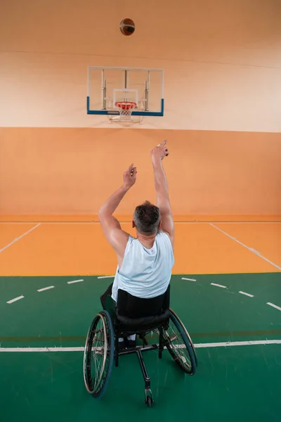 Uma foto de um veterano de guerra a jogar basquetebol numa arena desportiva moderna. O conceito de esporte para pessoas com deficiência — Fotografia de Stock