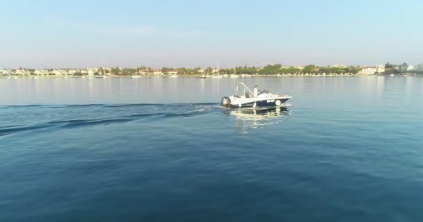 Strzał drona szczęśliwej rodziny na wakacjach jeżdżącej luksusową łodzią na pełnym morzu wczesnym rankiem — Wideo stockowe