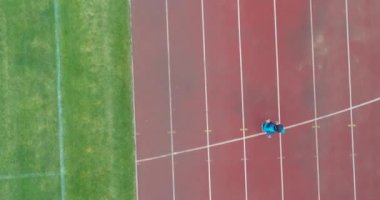 Genç Arap sporcunun tesettürlü atletik vücudu ile stadyum atletizm pistinde koşuşunun sinematik çekimi. Kavram: kararlılık, kadın gücü, hedef başarısı. Yüksek kalite 4k görüntü