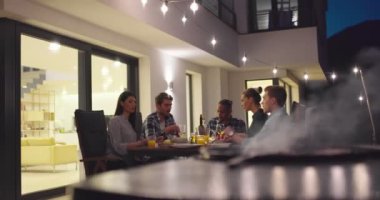 Akşamları yemek masasında bir grup arkadaş açık havada beraberler. 