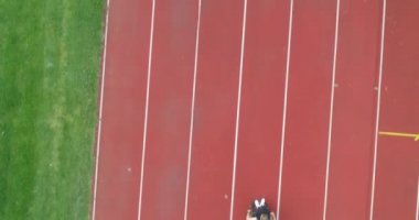 Engelli bir kadın atletizm pistinde tekerlekli sandalyede egzersiz yapıyor. Yüksek kalite 4k görüntü
