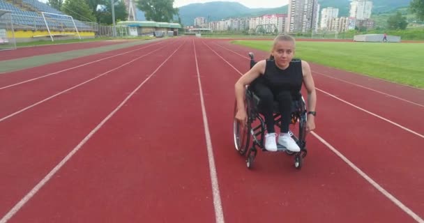 障害のある女性は 陸上競技場で車椅子でトレーニングを受けることができます 高品質4K映像 — ストック動画