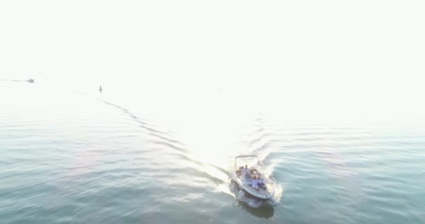 Een drone shot van een gelukkig gezin op een zomervakantie rijden een luxe boot op de volle zee in de vroege morgen — Stockvideo