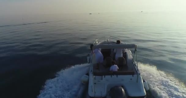 Ένα drone πλάνο μιας χαρούμενης οικογένειας σε καλοκαιρινές διακοπές οδηγώντας ένα πολυτελές σκάφος στην ανοιχτή θάλασσα νωρίς το πρωί — Αρχείο Βίντεο