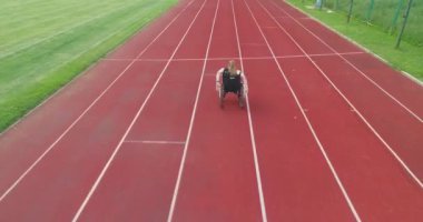 Engelli bir kadın atletizm pistinde tekerlekli sandalyede egzersiz yapıyor. Yüksek kalite 4k görüntü
