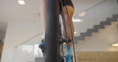 Bisikletli bir adam evde egzersiz yapıyor. Coronavirus Covid19 tecridi sırasında çevrimiçi bisiklet yarışı oynuyor. Yeni normal konsept. Yüksek kalite 8K görüntü