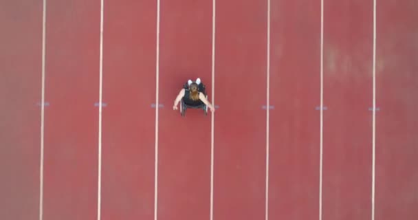 En kvinde med handicap har en træningsøvelse på atletikbanen. – Stock-video