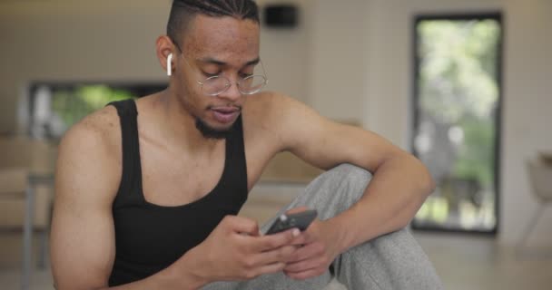 Modern Evde Egzersiz Yaptıktan Sonra Akıllı Telefon Kullanan Afro Amerikan — Stok video