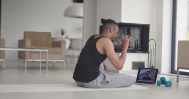 Afrikalı Amerikan fitness eğitmenleri dizüstü bilgisayarı müşteriyle çevrimiçi eğitim için ya da koronavirüs salgını sırasında çevrimiçi fitness dersi için kullanırlar. Yüksek kalite 4k görüntü