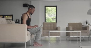 Afrikalı Amerikan fitness eğitmenleri dizüstü bilgisayarı müşteriyle çevrimiçi eğitim için ya da koronavirüs salgını sırasında çevrimiçi fitness dersi için kullanırlar. Yüksek kalite 4k görüntü