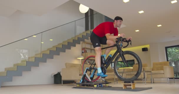 Homem Bicicleta Treinador Máquina Que Ele Está Exercendo Casa Jogando — Vídeo de Stock